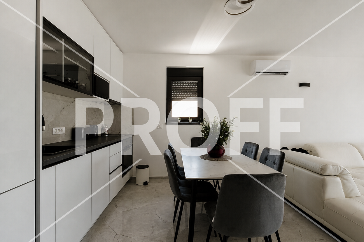 Open-plan kitchen and dining area with white cabinets and grey chairs